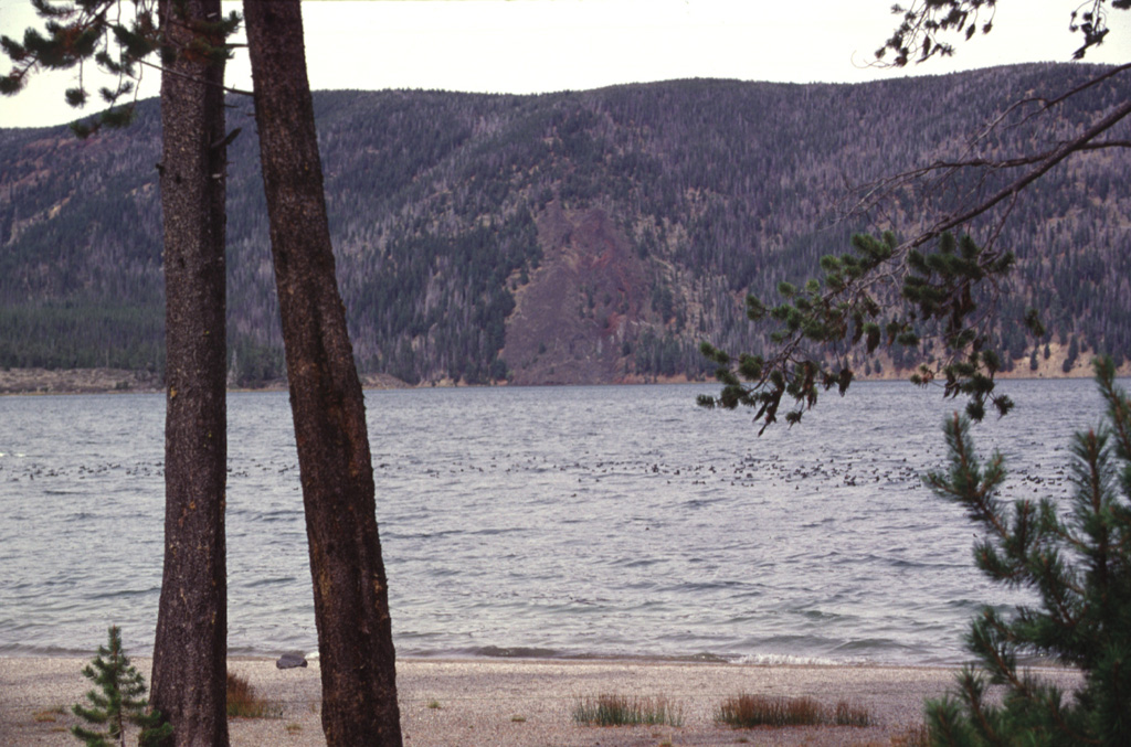 The East Lake Fissure (center) cutting through the northern rim of Newberry caldera is part of the northwest rift zone. The basaltic lava flow (the unvegetated area in the center of the photo) can be seen descending into the NE corner of East Lake.  Photo by Lee Siebert, 1997 (Smithsonian Institution).