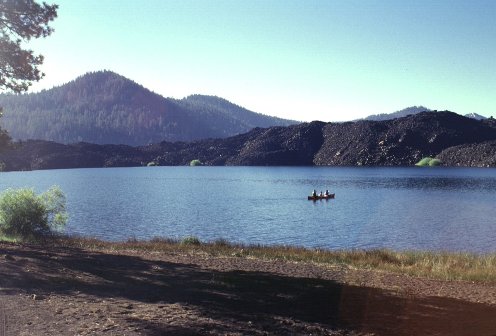 Butte Lake in NE Lassen Volcanic National Park was formed when the blocky lava flow seen across the lake dammed local drainages.  The flow was one of five accompanying the eruption that formed Cinder Cone several hundred years ago.  This marks the NW-most extent of lava flows from Cinder Cone. Photo by Lee Siebert, 1998 (Smithsonian Institution).