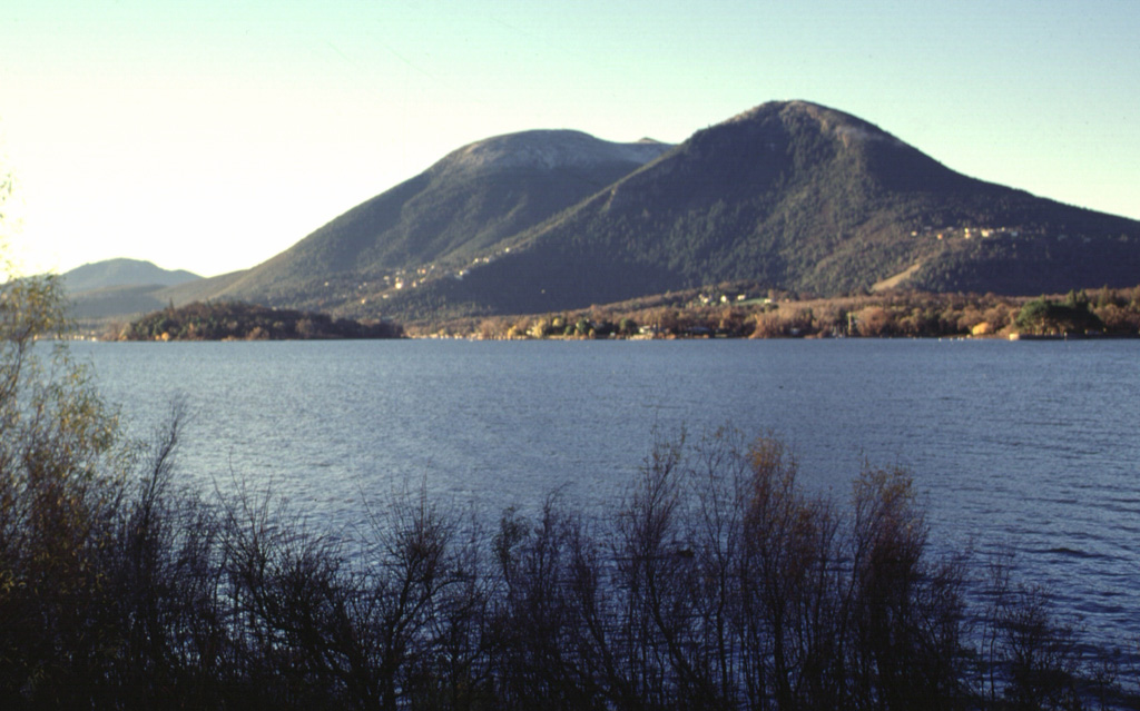 Mount Konocti, a composite dacitic volcano, rises above the southern shore of Clear Lake.  The arcuate escarpment facing the lake on the the NW-most peak, Buckingham Peak (right), is a landslide scarp produced when part of the dome collapsed.  A series of maars cuts the southern shore of Clear Lake, giving it a scalloped shoreline.  Clear Lake itself, the largest natural freshwater lake entirely within California, is an elongated, irregular body of water more than 30 km long.  It has a volcano-tectonic origin. Photo by Lee Siebert, 1997 (Smithsonian Institution).