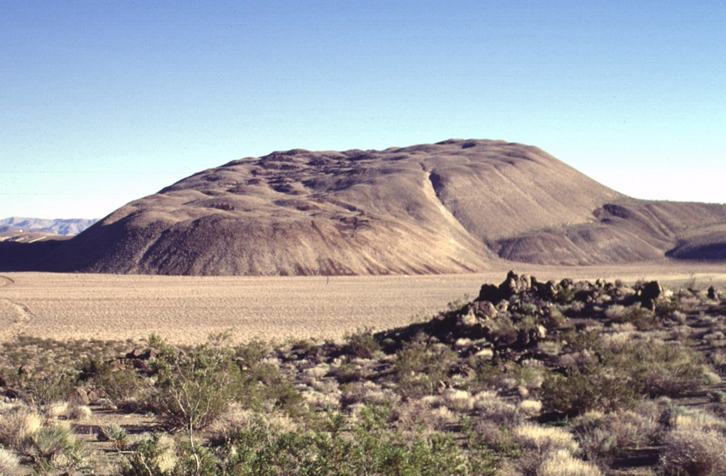 The Sugarloaf Mountain lava dome and associated lava flows, seen here from the west, is the largest of 38 rhyolitic lava domes of the Coso volcanic field, rising 300 m above its base.  The high-silica rhyolite of Sugarloaf Mountain contains localized areas of obsidian that were used as a source of arrowheads for native Americans.  The dome has been dated at about 41,000 +/- 21,000 years and is one of the youngest volcanic vents at Coso. Photo by Lee Siebert, 1997 (Smithsonian Institution).