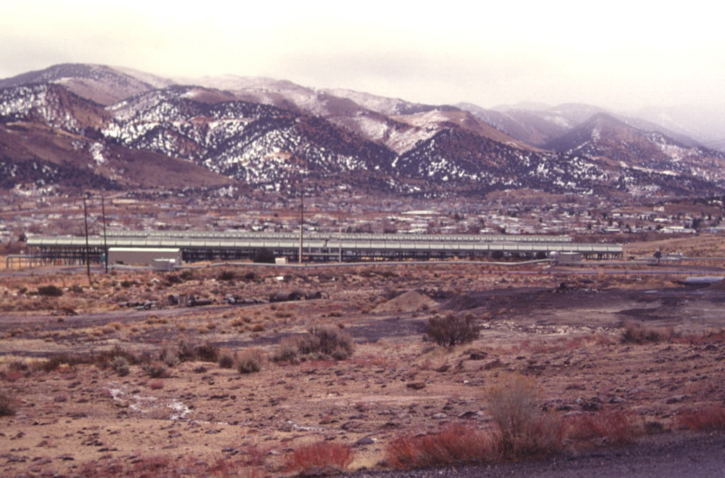 The elongated structure in the center of the photo is a power generating plant of the Steamboat Springs geothermal field.  The plant is easily visible from U.S. Highway 395 and Nevada 341 south of Reno.  Exploratory wells were drilled as early as the 1950s and 1960s, but the first successful well was drilled in 1979. Photo by Paul Kimberly, 1997 (Smithsonian Institution).