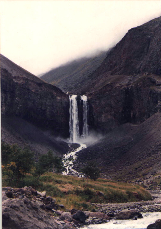 Water draining from Tianchi lake plunges over a mid-Pleistocene trachytic lava flow near the caldera rim on the upper N flank of Changbaishan (Baitoushan) volcano. Photo by Xiang Lui, 1983 (Changchun University).