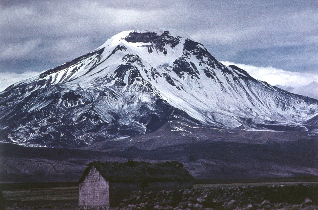 Volcán Pomerape is the northernmost of twin stratovolcanoes forming the Nevados de Payachata along the Chile-Bolivia border.  The 6282-m-high Pomerape lies across a saddle from Parinacota volcano, out of view to the right.  The glacially dissected Pomerape was constructed above a base of dacitic-rhyolitic lava domes.  The dominantly andesitic stratovolcano is capped by dacitic breccias and is of dominantly Pleistocene age. Photo by Oscar González-Ferrán (University of Chile).