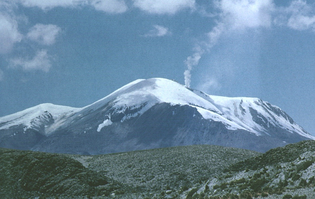 A vigorous steam plume rises from the summit ridge of Volcán Guallatiri, one of northern Chile's most active volcanoes. The ice-clad stratovolcano is seen here from the north and lies at the SW end of the Nevados de Quimsachata volcano group.  The 6071-m-high Guallatiri is capped by a central dacitic dome or lava complex, with the active vent situated at its southern side.  Minor explosive eruptions have been reported from Guallatiri since the beginning of the 19th century, and intense fumarolic activity continues. Photo by Oscar González-Ferrán (University of Chile).