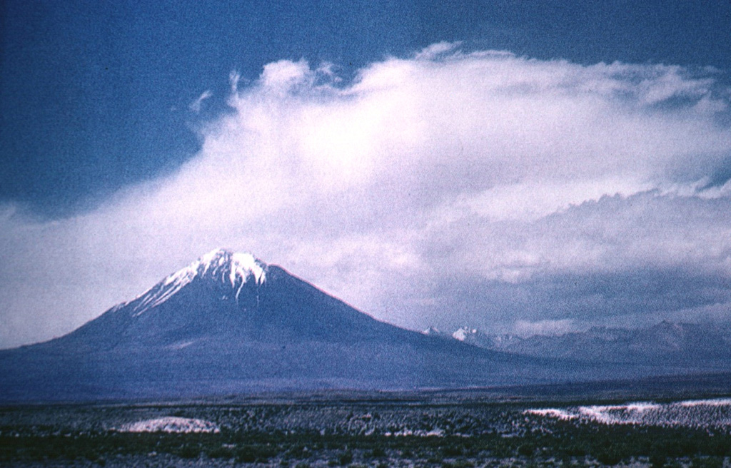 Towering 5980-m-high Tacora, the northernmost volcano of Chile, lies near the border with Perú and is a twin volcano with Chupiquina.  Tacora is seen here from the SE.  Although there have been uncertain reports of historical eruptions, and solfataric and fumarolic activity has been reported on the east side, Holocene eruptions from Tacora have not been documented. Photo by Oscar González-Ferrán (University of Chile).