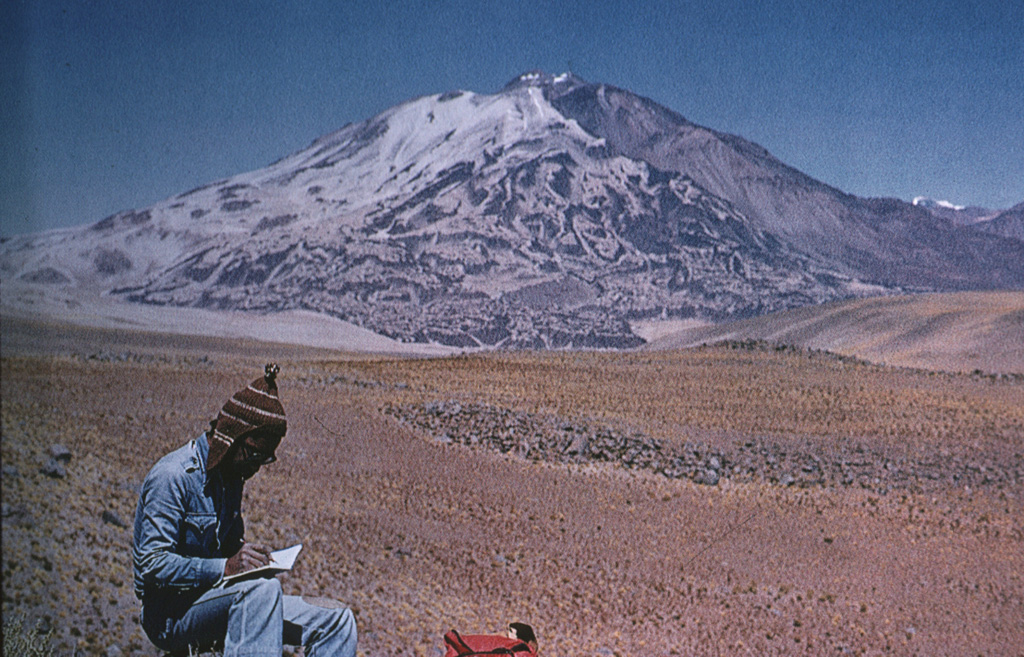 Volcán Socompa is a massive, 6051-m-high dacitic stratovolcano noted for an eruption about 7200 years ago, similar to that at Mount St. Helens in 1980.  The Socompa eruption produced a massive 600 km2 debris-avalanche deposit, much larger than at St. Helens, that extends about 40 km from the summit.  This view from the north shows dark-colored post-collapse lava domes on the right side that have filled much of the head of the massive collapse scarp, which extends to the base of the volcano at the lower right.   Photo by Carlos Felipe Ramírez (courtesy of Oscar González-Ferrán, University of Chile).