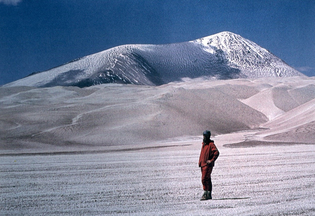 Light-colored rhyodacitic pyroclastic-flow deposits blanket El Solo volcano in the Ojos del Salado area.  Snow partially mantles the summit of El Solo, a stratovolcano composed of nine eruptive centers located west of Nevados del Ojos de Salado and SE of Tres Cruces volcano.  The 6190-m-high El Solo volcano was the source of major pyroclastic-flow deposits erupted during the Holocene that thickly fill adjacent valleys.  Photo courtesy of Oscar González-Ferrán (University of Chile).