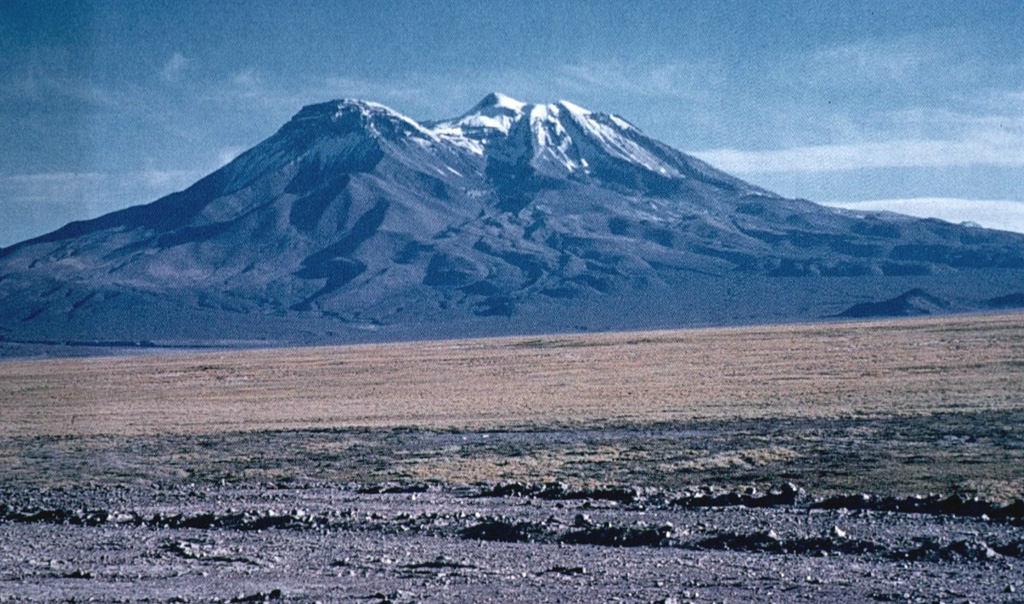 Cerro Paniri volcano, seen here rising to the NE above the Río Loa valley, is a complex stratovolcano located about 30 km SE of San Pedro volcano.  Cerro Paniri volcano consists of andesitic-to-dacitic lava flows and pyroclastic materials.  The summit of 5946-m-high Paniri contains three craters separated by about 4 km along a NW-SE trend.   Photo by Oscar González-Ferrán (University of Chile).