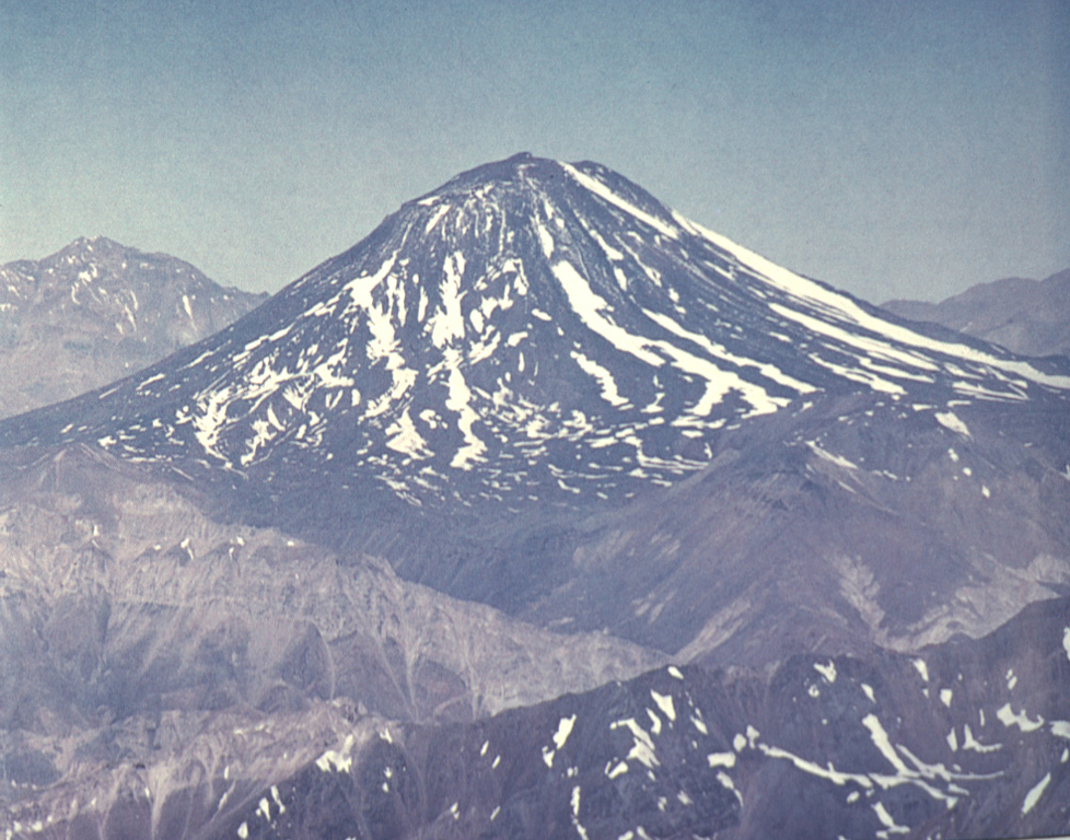 Maipo volcano, seen here from the west, partially fills the Pleistocene Diamante caldera.  The floor of the large 15 x 20 km caldera, which formed about 0.45 million years ago during an eruption that produced a 450 cu km ignimbrite, is visible below Maipo.  The 5264-m-high basaltic-andesite stratovolcano has a relatively simple structure, but has a flank rhyodacitic lava-dome complex and pyroclastic cones on its eastern flank.  Lava flows from these cones extend into Laguna Diamante on the eastern side of the caldera. Photo by Wolfgang Foerster, courtesy of Oscar González-Ferrán (University of Chile).