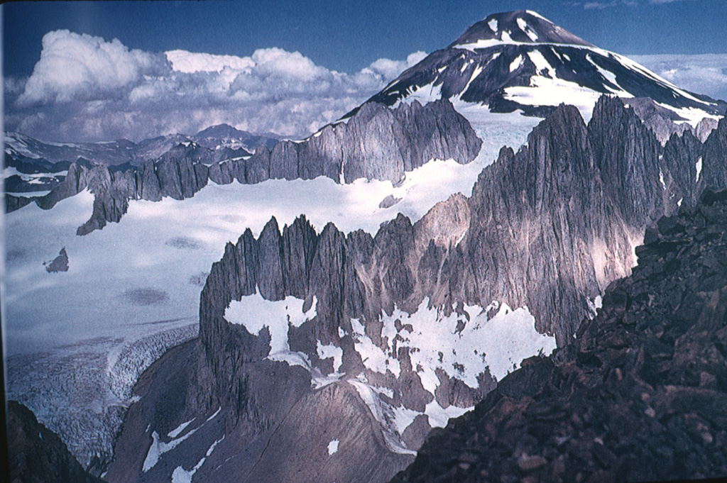 Palomo is a small, 4850-m-high stratovolcano that is seen here from the NNE rising above ruggedly dissected basement rocks.  Palomo was constructed within double calderas, 3 and 5 km in diameter, respectively.  A flank cone, Andres, is postglacial in age and has produced andesitic lava flows.  Palomo has erupted basaltic-andesite to dacitic lava flows.  No historical eruptions are known from Palomo, although its youthful morphology suggests a very young age.      Photo by Wolfgang Foerster, courtesy of Oscar González-Ferrán (University of Chile).