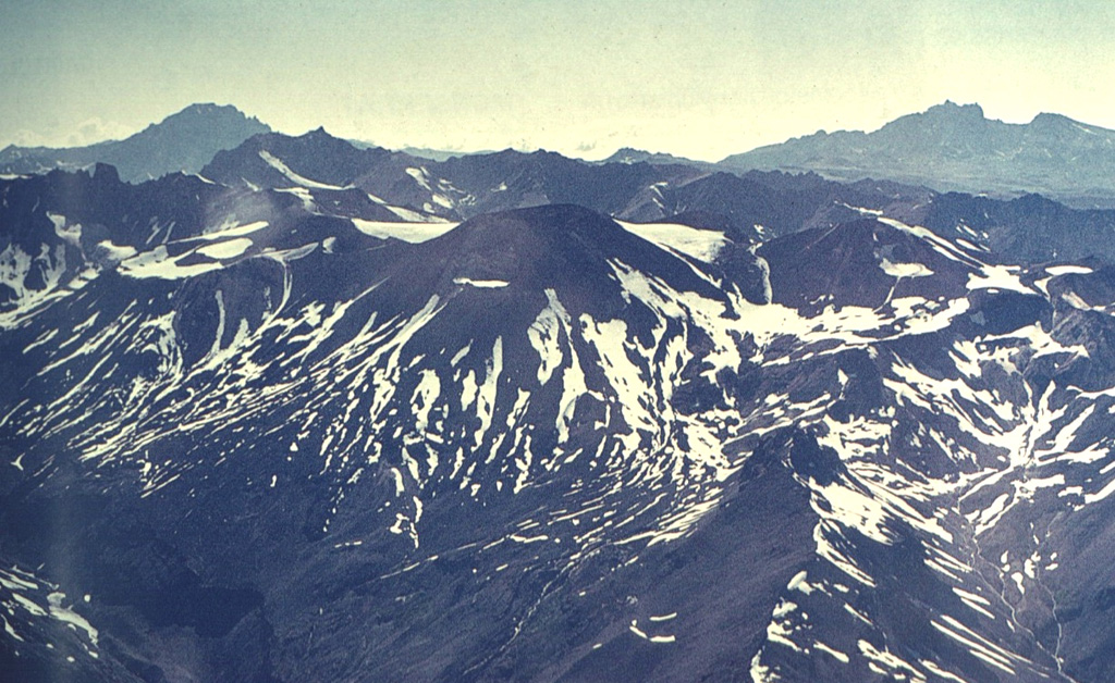 Tinguiririca is composed of at least seven Holocene scoria cones constructed along a N-S fissure over an eroded Pleistocene stratovolcano.  The central part of the chain from Tinguiririca to Fray Carlos is seen in this view.  Sulfur deposits are found on the western flanks of the summit cones.  A single historical eruption from Tinguiririca was recorded in 1917.      Photo by Oscar González-Ferrán (University of Chile).