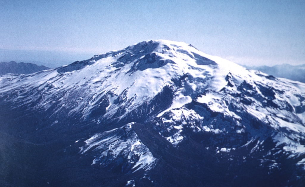 The ice-capped, 3164-m-high Callaqui volcano has an elongated profile due to construction along an 11-km-long, SW-NE-trending fissure.  As many as 16 well-preserved volcanic craters, the majority of which are on the SW flank, have erupted along this fissure and produced lava flows that mantle the volcano's flanks.  Two large, ice-filled craters are located at the summit, and intense solfataric activity occurs on the southern side.   Photo by Oscar González-Ferrán (University of Chile).