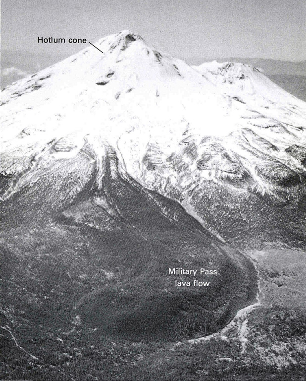 An aerial view shows the Military Pass lava flow on NE side of Mount Shasta, the longest known lava flow from the volcano, erupted about 9,200 years ago. It originated near the summit of the Hotlum cone and reached about 9 km, with a thickness of about 150 m thick near its terminus. The flow overlies the Red Banks pumice and a broad fan of pyroclastic flow deposits that were formed around 9,700 years ago. Photo by Dan Miller, 1980 (U.S. Geological Survey).