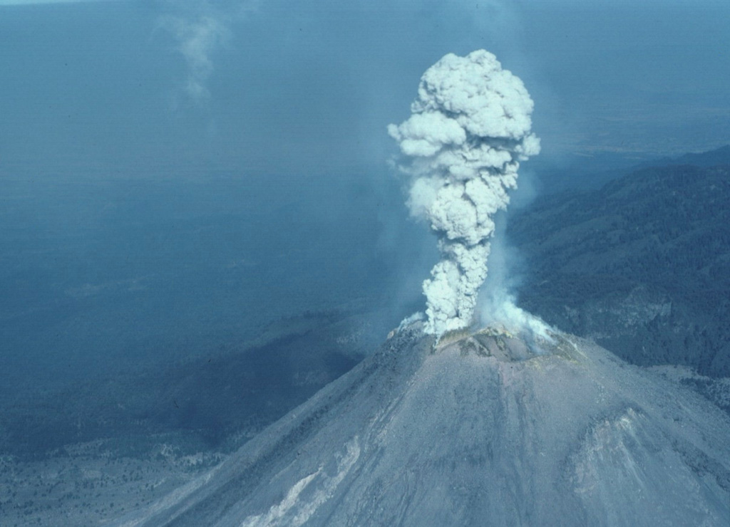 A small explosion 8 February 1999 produced a plume of gas and minor ash that is seen here from the SE about 5 seconds after the explosion began. Rapid lava extrusion began on 20 November 1998 and produced a lava dome in the 1994 crater that soon flowed over the crater rim, producing lava flows that descended the SW flank in several lobes. Block-and-ash flows from collapse of the flow fronts traveled down SW flank drainages. Periodic larger explosions occurred later during this eruption. Photo by Jim Luhr, 1999 (Smithsonian Institution).