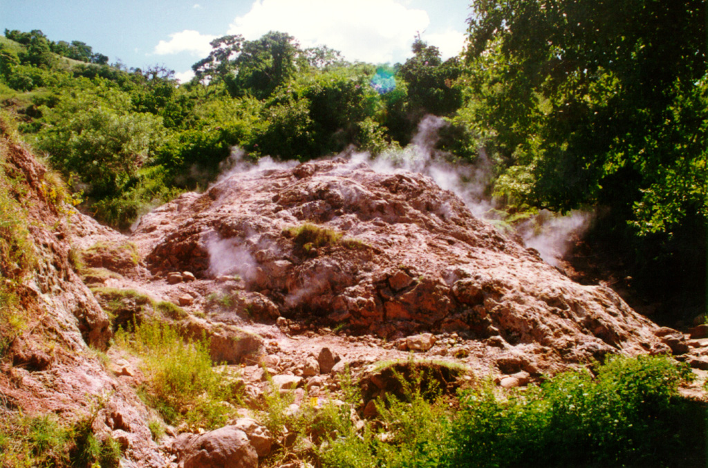 Gases rise from fumaroles within hydrothermally altered rock on the Chinameca northern flank. Fumarole fields surround the city of Chinameca on several sides, within a few kilometers of the town. Photo courtesy of Comisión Ejecutiva Hidroeléctricia del Río Lempa (CEL).
