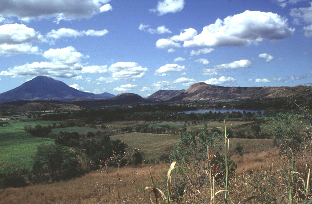 The Apastepeque volcanic field consists of a cluster of about two dozen lava domes, scoria cones, and craters NE of San Vicente volcano, the large edifice to the left. The Laguna de Apastepeque crater is to the right, below Cerro Las Delicias lava dome. Near the center of the horizon is Cerro Santa Rita lava dome. Photo by Carlos Pullinger, 1996 (Servicio Nacional de Estudios Territoriales, El Salvador).