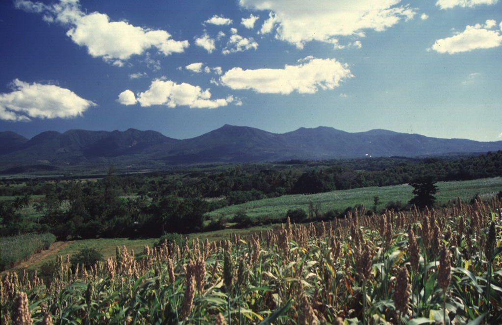 The northern side of the broad Apaneca Range is seen here from El Rodeo. From left to right are Cerro Cuyanausul, Laguna Verde (the center peak), Las Ninfas, and the Cerro La Cumbre complex. The E-W-trending chain of overlapping Pleistocene and Holocene volcanoes of the Apaneca Range forms a major topographic barrier in western El Salvador. Photo by Carlos Pullinger, 1996 (Servicio Nacional de Estudios Territoriales, El Salvador).