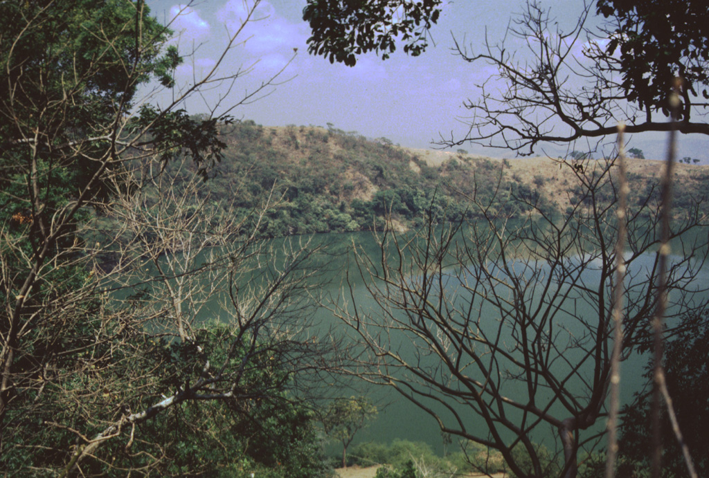 Laguna Chalchuapán is one of several maars in the Apastepeque volcanic field. The 700-m-wide crater is located immediately NE of the Hoyo de Calderas crater. Lahar deposits underlie pumice deposits exposed in the crater walls.  Photo by Giuseppina Kysar, 1999 (Smithsonian Institution).