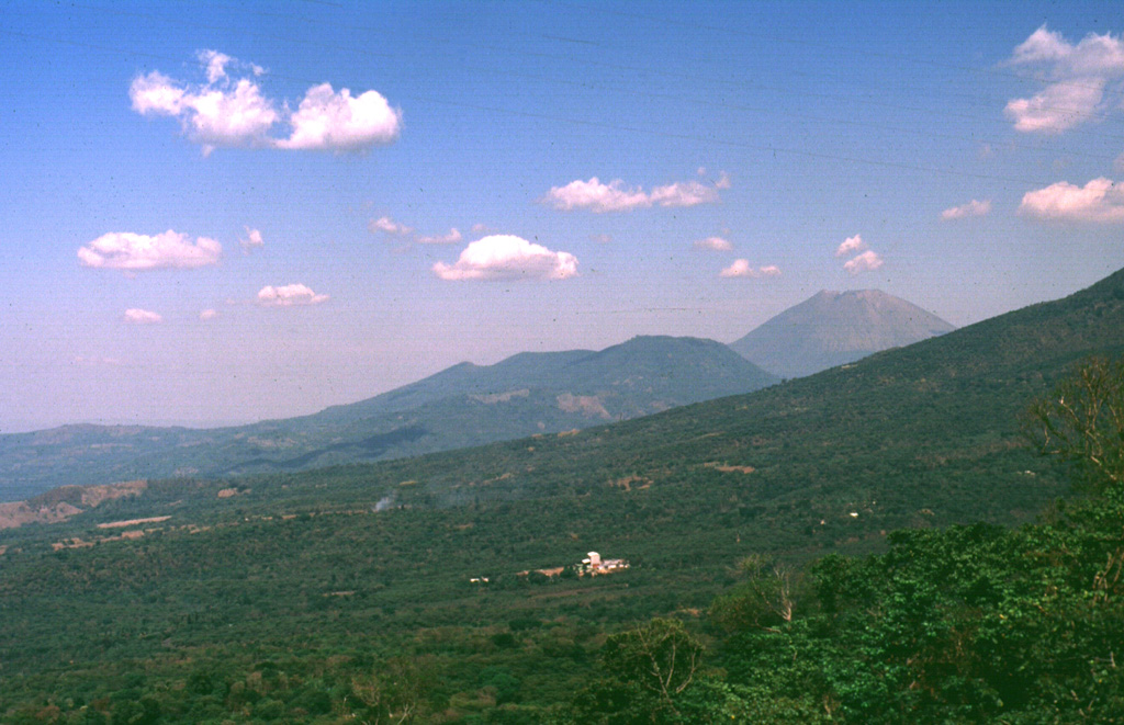 The Chinameca volcanic complex is seen here from the west beyond the lower flank of Pleistocene El Tigre volcano. The lower peak at the right side of the Chinameca complex is Cerro el Limbo, a cone on the western flank of Chinameca caldera. The higher peak at the upper right is San Miguel volcano, which is separated by a low saddle from Chinameca. Photo by Carlos Pullinger, 1994 (Servicio Nacional de Estudios Territoriales, El Salvador).