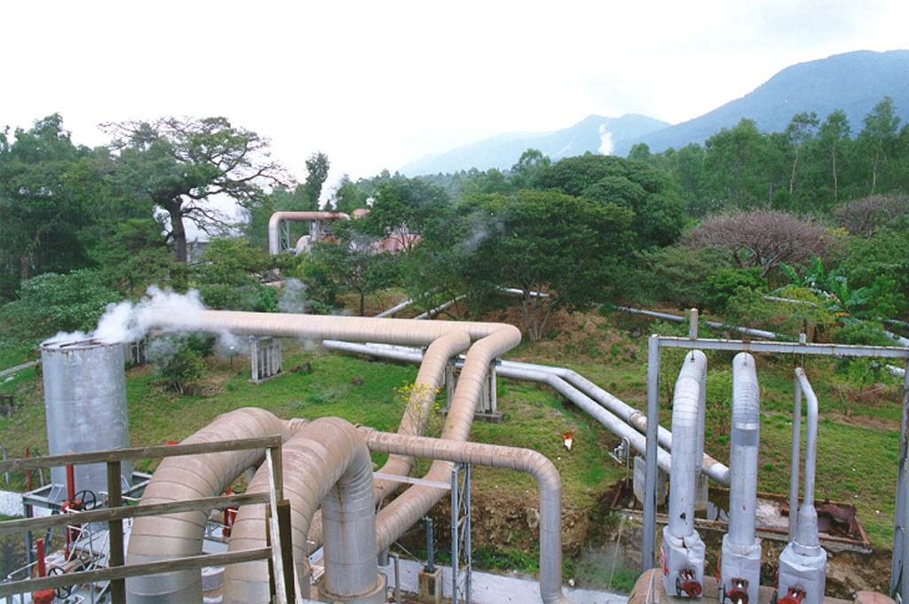 Steam lines going to the power plant snake across the surface of the Ahuachapán-Chipilapa geothermal field in western El Salvador.  The field is located on the northern flank of the Sierra de Apaneca range 15 km from the Guatemala border.  The Ahuachapán-Chipilapa field was the first to be developed in El Salvador and began production in 1975. Photo courtesy of Comisión Ejecutiva Hidroeléctricia del Río Lempa (CEL).