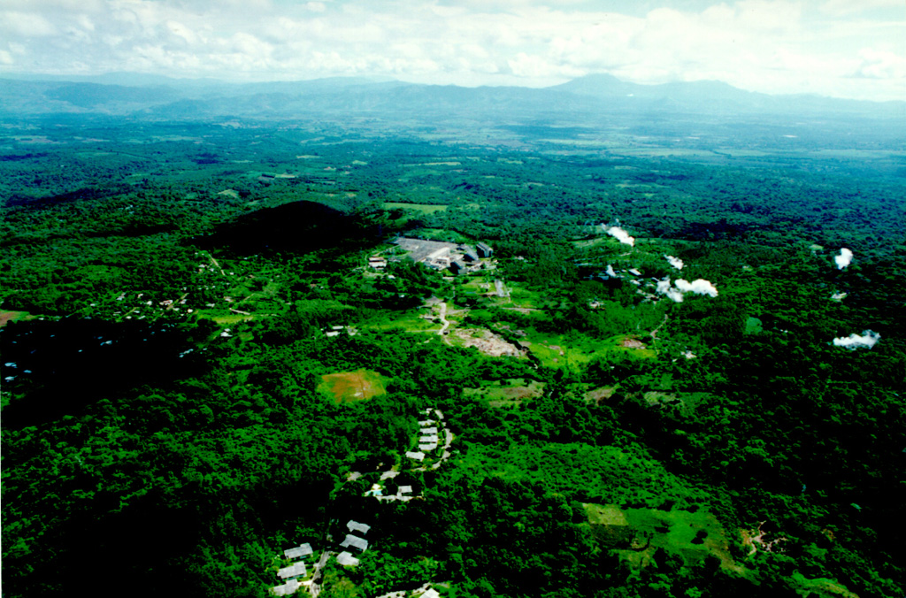 This aerial view shows the Ahuachapán-3 geothermal power plant.  The Ahuachapán-Chipilapa geothermal field has an installed capacity of 95 MW and a potential of 95-150 MW.  It covers an area of 200 km2 in the counties of Santa Ana, Ahuachapán, and Sonsonate.  The field was the first developed in El Salvador, and the first plants came on line in 1975.  During the 1980s the field was over-exploited and generated more than 40% of the country's electricity.  After the reservoir pressure dropped rapidly, generation was stabilized at 48 MW. Photo courtesy of Comisión Ejecutiva Hidroeléctricia del Río Lempa (CEL).