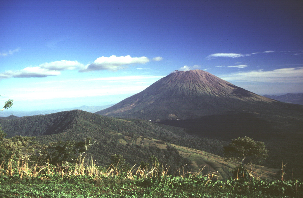 Conical San Miguel volcano, one of El Salvador's most prominent landmarks, rises across a low saddle SE of Chinameca (Pacayal) volcano.  The 2130-m-high San Miguel is seen here from Cerro el Limbo, a cone on the western flank of Chinameca.  The southern side of Chinameca's 2-km-wide summit caldera is visible at the left. Photo by Carlos Pullinger, 1996 (Servicio Nacional de Estudios Territoriales, El Salvador).