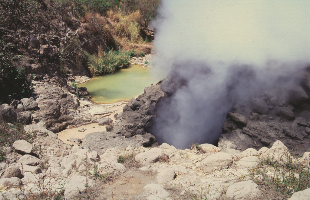 Ausoles de la Labor fumaroles and hot pools form one of the largest geothermal areas in the Ahuachapán geothermal field. The area is located near the SW base of the Cerro San Lazaro lava dome, about 5 km N of Laguna Verde volcano. The Ahuachapán geothermal field contains fumaroles, mud volcanoes, or hot springs, throughout a roughly 80 km2 area on the northern flank of the Apaneca Range. Photo by Giuseppina Kysar, 1999 (Smithsonian Institution).