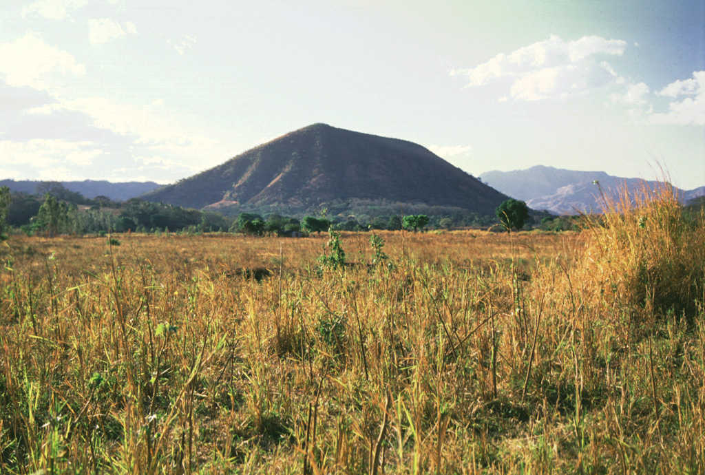 Cerro Singüil is a large scoria cone with a summit crater that lies at the eastern end of a large volcanic field in the interior valley of El Salvador near the Guatemalan border, SE of Volcán Chingo. Cerro Singüil is seen here from the SE along the Pan-American Highway, around the eastern flank of the cone. Photo by Giuseppina Kysar, 1999 (Smithsonian Institution).