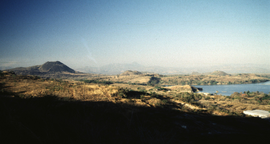 A panoramic view from the NE shows from left to right Volcán de San Diego, Cerro Masatepeque, and Loma Iguana. Laguna de Metapán is to the right. San Diego is the largest cone of a volcanic field surrounding Lake Güija on the El Salvador/Guatemala border. Lava flows from smaller vents of the San Diego volcanic field were responsible for blocking drainages and forming Laguna de Metapán, and the larger Lago de Güija was formed as a result of flows from Volcán de San Diego. Photo by Giuseppina Kysar, 1999 (Smithsonian Institution).