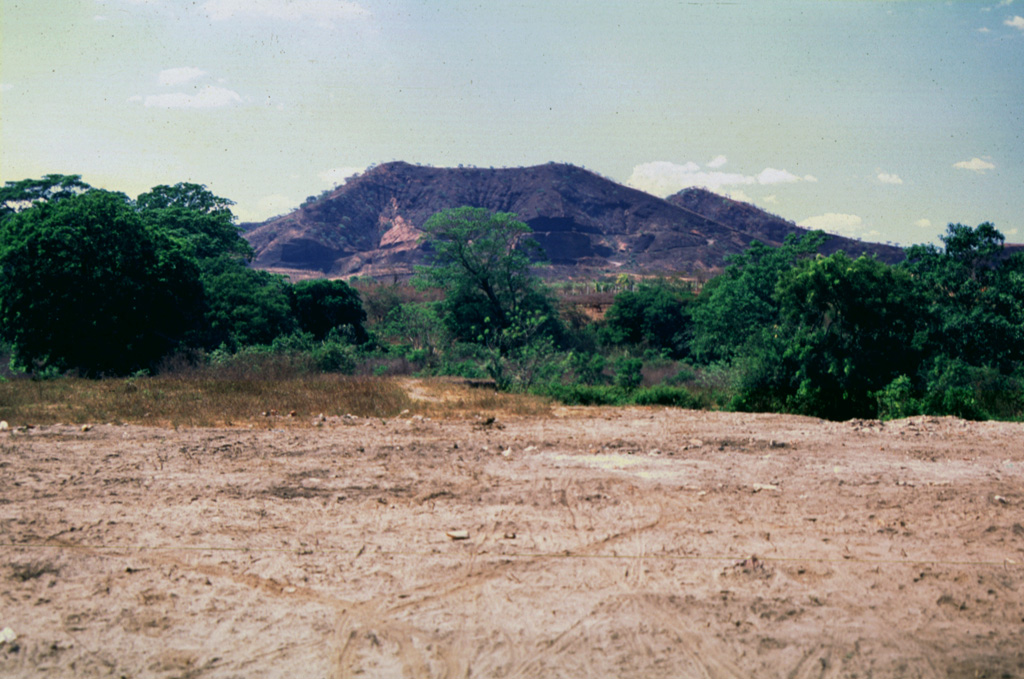 Cerro El Chino is seen here from the east, just south of the town of Aguilares and is part of the Cerro Cinotepeque volcanic field, a large group of small Pleistocene-to-Holocene stratovolcanoes and cones constructed along NW-SE-trending faults on either side of the Río Lempa west of Guazapa volcano. The Holocene Cerro Cinotepeque cone lies about 6 km NW of Cerro El Chino. Photo by Giuseppina Kysar, 1999 (Smithsonian Institution).
