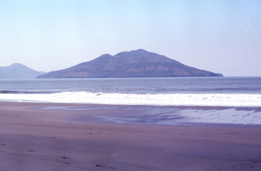 Conchagüita volcano occupies a small, 4-km-wide island in the Gulf of Fonseca across a narrow strait from Conchagua volcano.  Conchagüita is seen here from Punta El Chiquirín, the easternmost point on the Salvadoran mainland.  Late-stage eruptions formed a small, sharp-topped cone with a 100-m-wide summit crater at the southern end of the low 550-m-high island.  Minor ash emissions in 1892 marked the only reported historical eruption from Conchagüita.  Meanguera Island can be seen beyond Conchagüita at the left. Photo by Francesco Frugioni, 1999 (Istituto Nazionale di Geofisca e Vulcanologia, Rome).