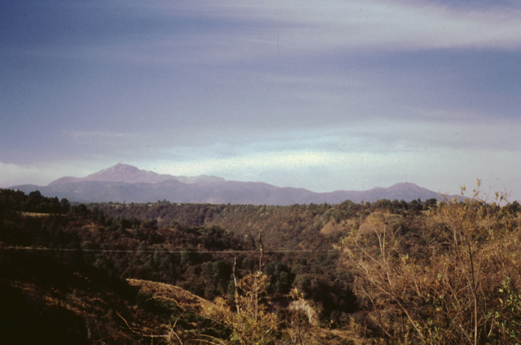 Nevado de Toluca is seen here from the south with its highest peak El Fraile to the left. The volcano is also known by its Nahuatl name, Xinantécatl. The morphology is due in part to explosive eruptions, large slope failures, and glacial erosion. Nevado de Toluca lies 80 km WSW of Mexico City. Photo by José Macías, 1995 (Universidad Nacional Autónoma de México).