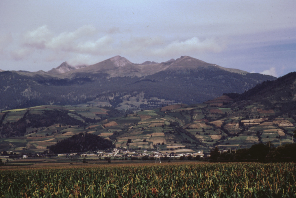 The horseshoe-shaped summit crater of Toluca beyond the east-flank town of San Antonio Balderas opens towards the east. Block-and-ash flows from late-Pleistocene eruptions about 40,000 and 28,000 years ago cover this and other flanks of the volcano over an area of 630 km2. Photo by José Macías, 1996 (Universidad Nacional Autónoma de México).