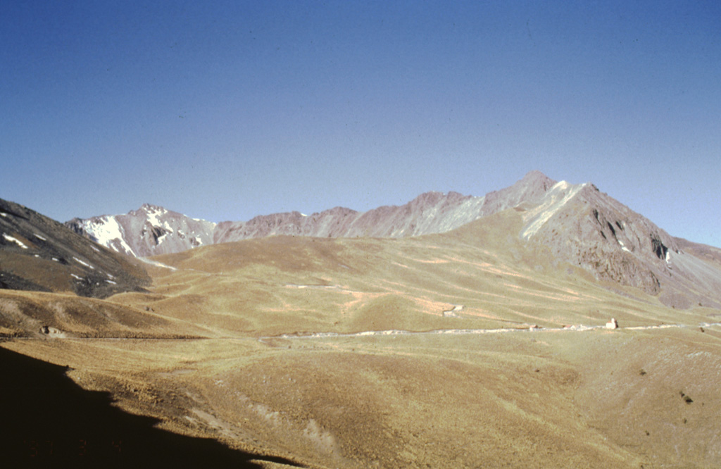 The far western crater rim of Nevado de Toluca volcano is seen here on the horizon from the NE. The road into the crater is across the center of the photo below the low, smoother northern crater rim. The smooth surface of the northern flank consists of a lava flow that was modified by extensive Pleistocene-Holocene glacial erosion.  Photo by José Macías, 1997 (Universidad Nacional Autónoma de México).