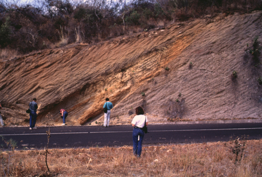 Geologists investigate an exposure in the Popocatépetl southern flank of along the road connecting the towns of Hueyapan and Amayuca in the state of Morelos. The outcrop shows two debris avalanche deposits separated by a yellowish reworked horizon. The deposit to the left corresponds to the youngest avalanche produced by the southern flank failure of the ancient Popocatépetl around 23,000 years ago. Major flanks collapse events have occurred at least three times during the Pleistocene. Photo by José Macías, 1995 (Universidad Nacional Autónoma de México).