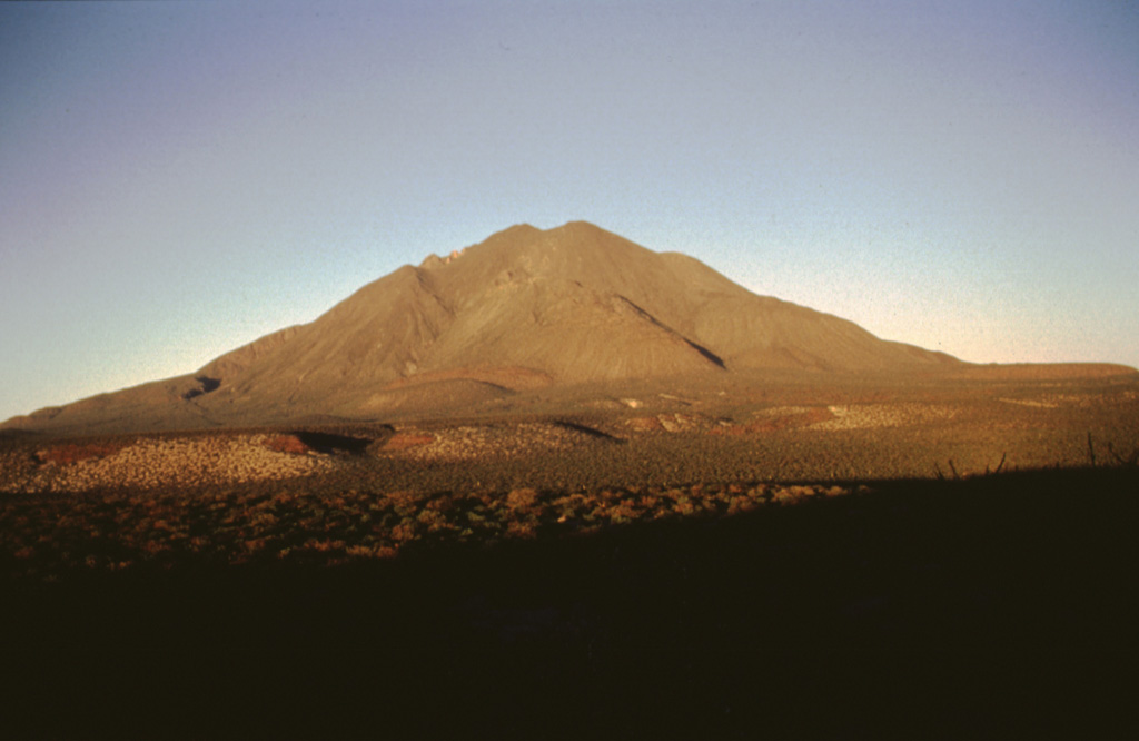 This view shows the SSW flank of Tres Vírgenes in Baja California. Much of the volcano consists of lava domes and viscous lava flows. The hills on the flanks are rhyodacite lava flows associated with a Plinian eruption. The aligned flat-topped terraces on the plain are underlain by basaltic andesitic lava flows of Tertiary age.  Photo by José Macías, 1995 (Universidad Nacional Autónoma de México).
