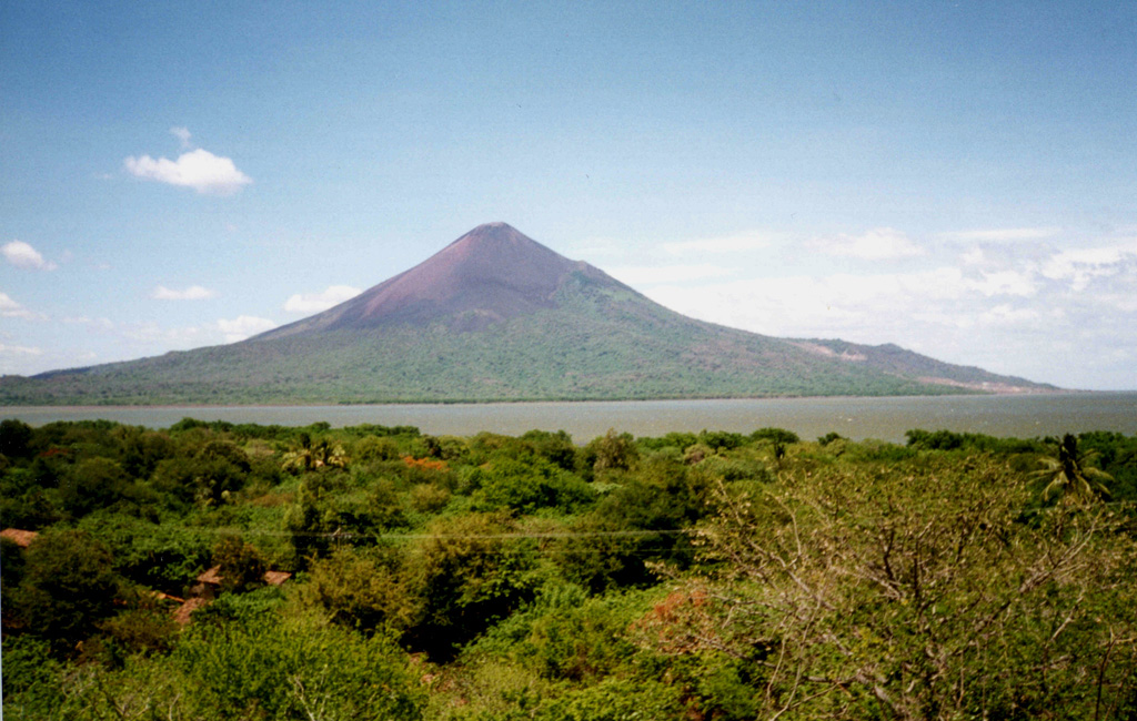 Momotombo volcano, seen here from the west near Puerto Momotombo, towers about 1250 m above Lake Managua.  The volcano was constructed beginning about 4500 years ago SE of Monte Galán caldera, which lies out of view to the left.  Geothermal exploration has occurred on its southern flank (the light-colored area at the right). Photo by Pat Dobson, 1998 (Lawrence Berkeley National Laboratory).