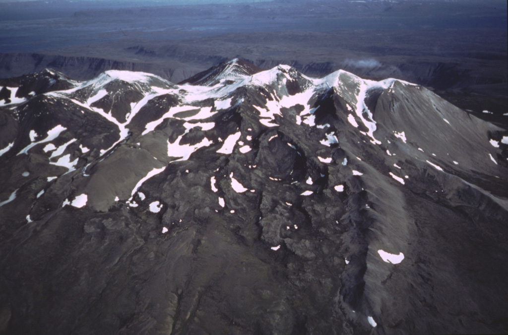The Ljósufjöll volcanic system at the eastern end of the Snæfellsnes Peninsula is contains a group of scoria cones and lava flows along a roughly 90-km-long WNW-ESE trend. The crest of the Ljósufjöll range is seen here from the south with glacial moraines descending the flanks. Photo by Oddur Sigurdsson, 1983 (Icelandic National Energy Authority).