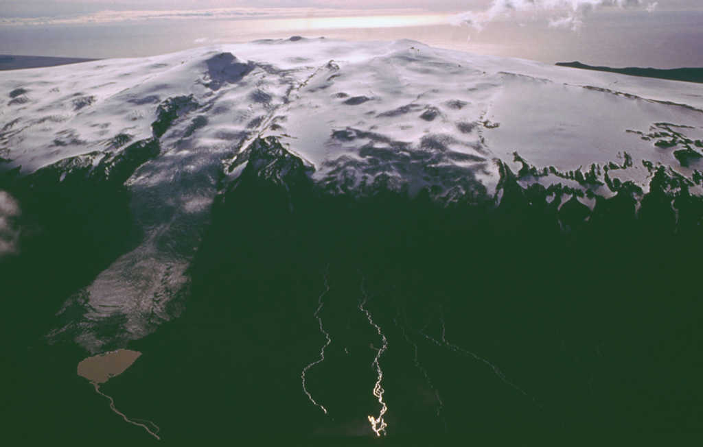 The summit ridge of Eyjafjallajökull is seen here in 1992 from the NW with a steep-sloped valley glacier descending at the left toward the Markafljot plain. The summit is truncated by a 2.5-km-wide, ice-filled caldera breached to the north (towards bottom left). Prior to 2010, the last eruption known from Eyjafjallajökull was during December 1821 to January 1823. Photo by Oddur Sigurdsson, 1992 (Icelandic National Energy Authority).