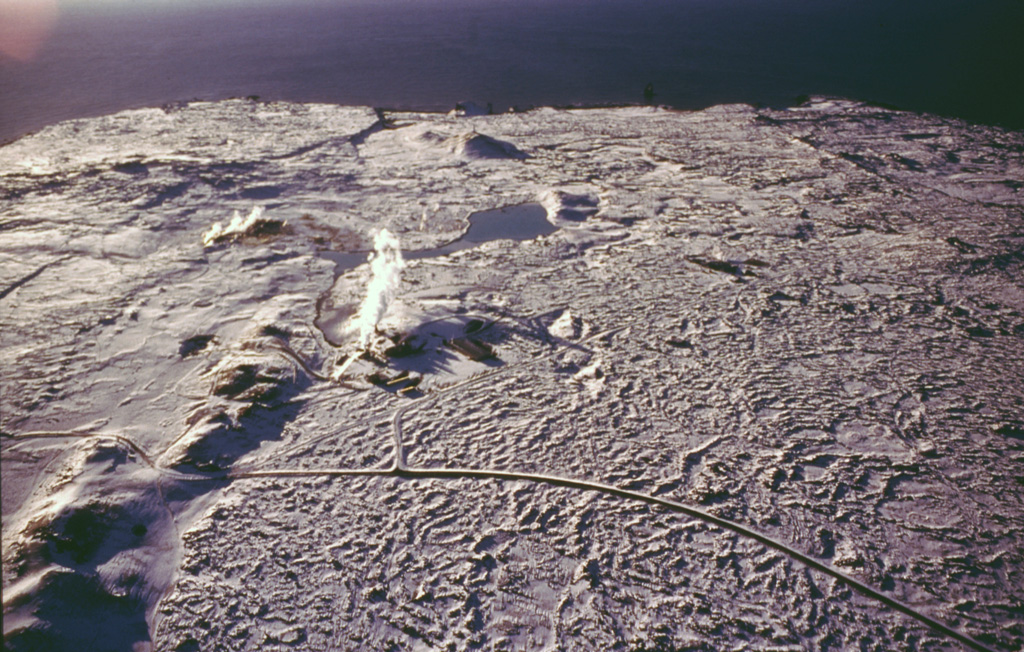 The submarine Reykjaneshryggur volcanic system, lying off the southwest tip of Iceland, is part of the Mid-Atlantic Ridge, which extends onto the Reykjanes Peninsula (foreground). A small plume of steam from geothermal activity is visible (middle left). Numerous submarine eruptions at Reykjaneshryggur dating back to the 13th century have been observed, some of which have formed short-lived islands. Submarine eruptions have been characterized by phreatomagmatic or Surtseyan explosive activity, depositing tephra on land. Subaerial eruptions have been typified by effusive activity, producing lava flows on Reykjanes Peninsula.  Photo by Oddur Sigurdsson, 1998 (Icelandic National Energy Authority).