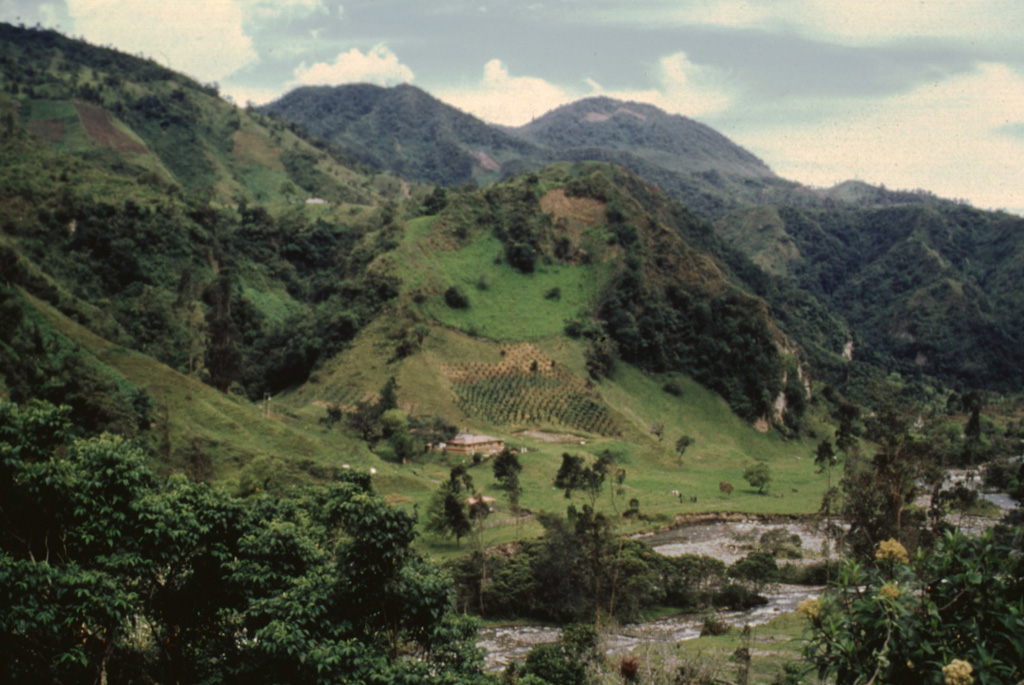 The terraces along the Toche River are composed of thick pyroclastic flow deposits produced during Holocene explosive eruptions of Cerro Machín. The summit lava domes are seen on the horizon in this view from the NNW. This small but explosive volcano is located at the southern end of the Ruiz-Tolima massif.  Photo by José Macías, 1996 (Universidad Autómona de México).
