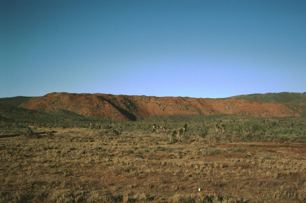 The ridge in the background is a thick basaltic andesite lava flow of probable Holocene in age that is part of the San Borja Volcanic Field. The flow is seen here from State Highway 1 in central Baja California. The sparsely vegetated flow is one of many younger lava flows of the field.  Photo by Andy Saunders, 1984 (University of Leichester).