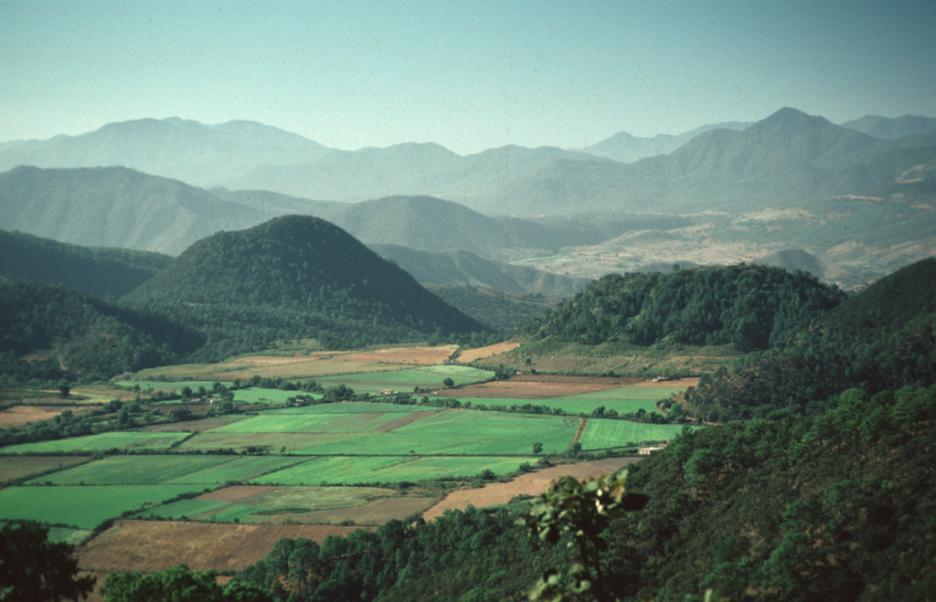 Volcán Tecomate (left of center) and flat-topped Volcán Molcajete (to the right), seen here from the NW, are two of the scoria cones and domes of the Mascota Volcanic Field. These are part of a group cinder cones and lava flows located within the Talpa and Mascota grabens near the town of Mascota, east of Puerto Vallarta.  Photo by Paul Wallace, 1987 (University of California Berkeley).