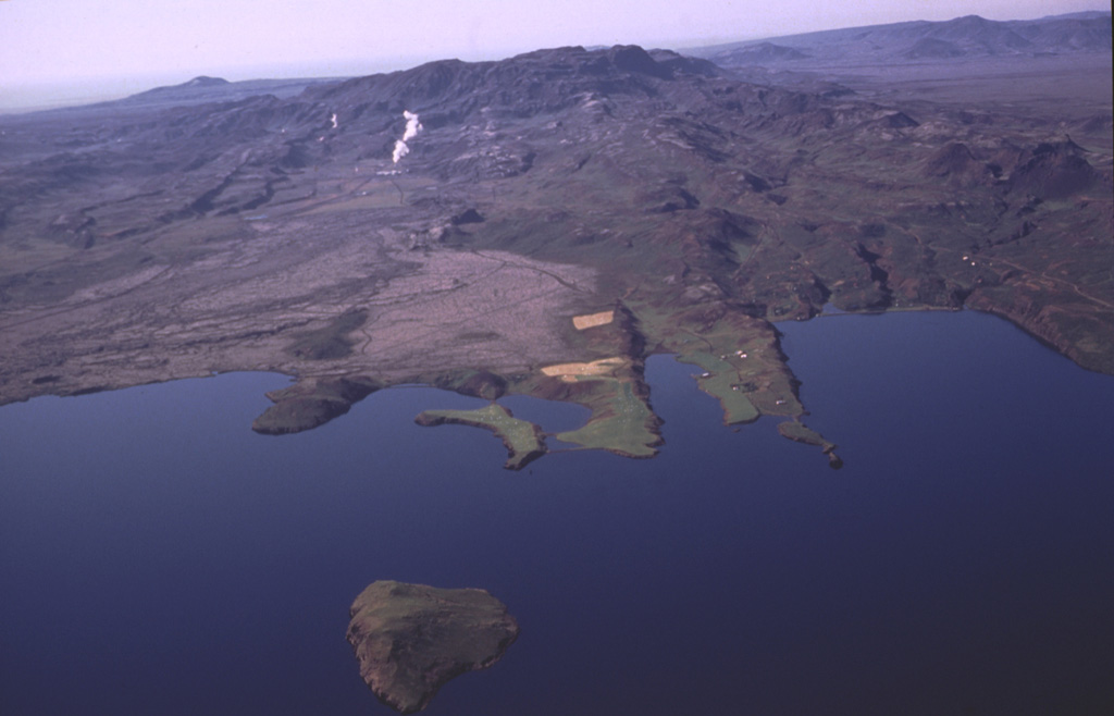An aerial view from the NE shows the Hengill central shield volcano on the center horizon rising above Thingvallavatn lake. Steam rises from the Nesjavallavirkjun geothermal area in front of the peak. NE-trending fault scarps extend into the lake. Holocene fissure-fed eruptions have occurred from vents both northeast and southwest of the Hengill central volcano, with fissures extending into the lake. Just out of the bottom of the picture (north) is an island where phreatomagmatic activity created a tephra ring called Sandey about 1,900 years ago. Photo by Oddur Sigurdsson, 1998 (Icelandic National Energy Authority).
