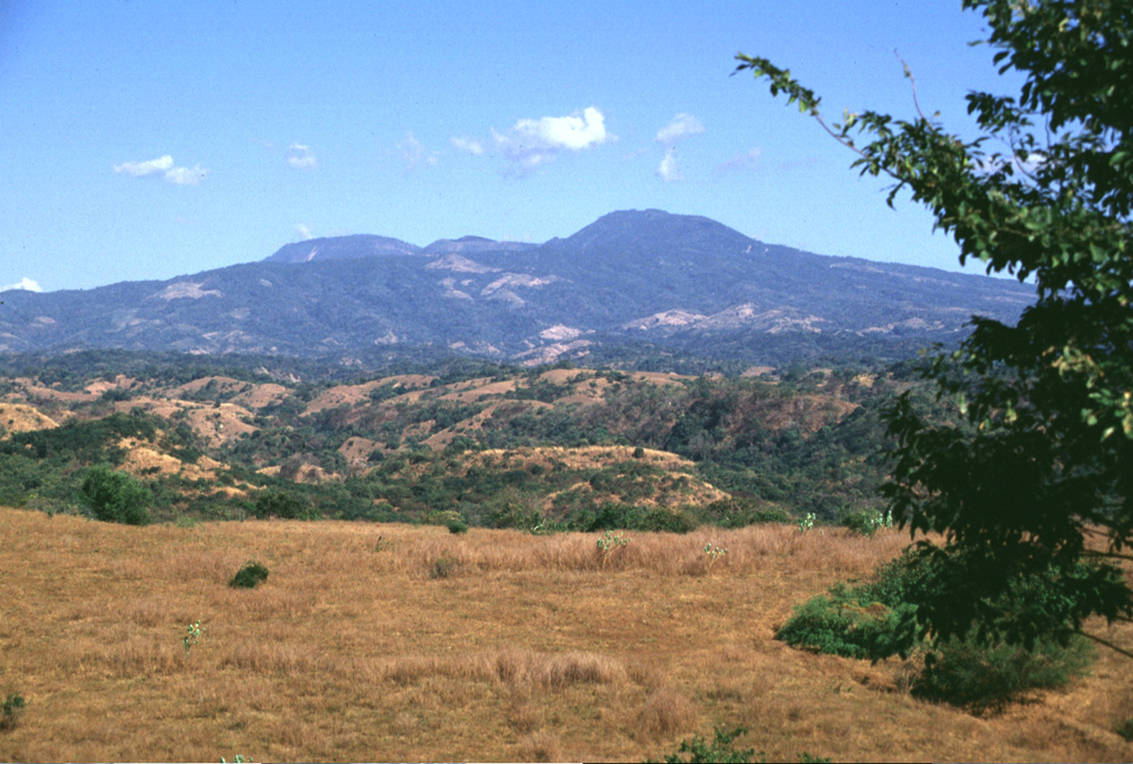 Tecapa is at the NW end of a cluster of volcanoes in eastern El Salvador between San Vicente and San Miguel, seen here from the west. The peaks on the horizon to the far left lie behind the Berlín caldera. Geothermal activity continues within the Tecapa volcanic complex  and a producing geothermal plant is located at the Berlín geothermal field. Photo by Lee Siebert, 1999 (Smithsonian Institution).