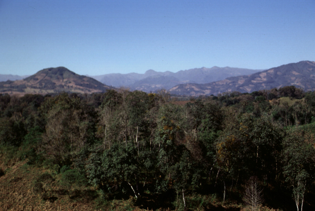 The broad ridge on the horizon is Las Cumbres volcanic complex, a Quaternary center NNE of Pico de Orizaba that contains a 3.5-4.5 km wide summit caldera. The Las Cumbres complex lies in the southern half of the Pico de Orizaba-Cofre de Perote volcanic chain and is topographically much less prominent than the two major volcanoes at the ends of the chain. Photo by Lee Siebert, 1998 (Smithsonian Institution).