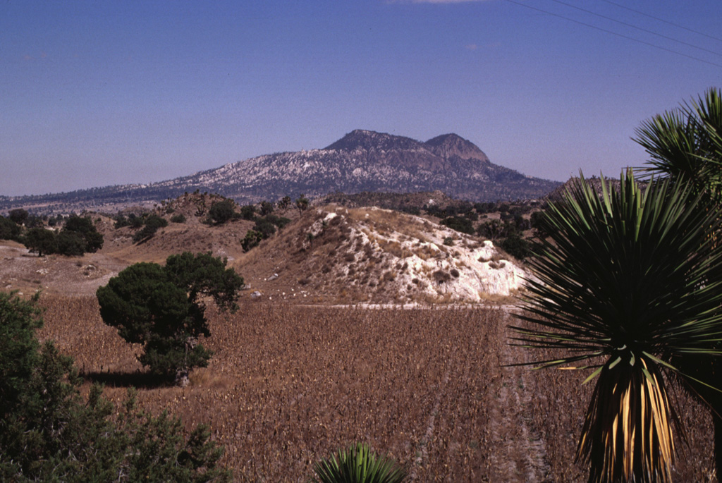 Cerro Pinto on the NE horizon is a lava dome that formed within a tuff cone. Cerro Pinto is one of several large lava domes within the enclosed Serdán-Oriental basin. The hills in the foreground are hummocks of a debris avalanche deposit produced by collapse of Las Derrumbadas lava domes. Photo by Lee Siebert, 1997 (Smithsonian Institution).