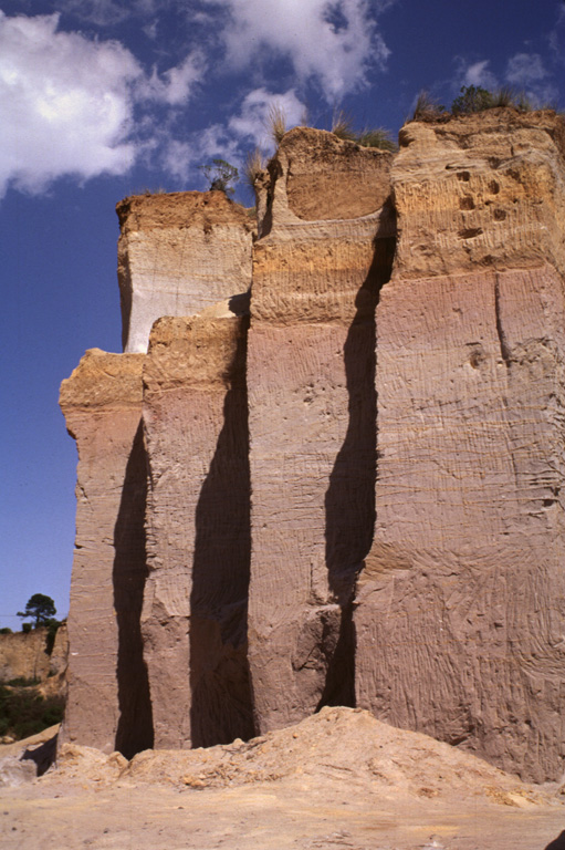 A quarry wall on the lower NW flank of Cofre de Perote volcano exposes a cross-section through part of the Xáltipan Ignimbrite, which erupted about 460,000 years ago and resulted in the formation of Los Humeros caldera. This massive 230 km3 ignimbrite covers a 3,500 km2 area and extends at least 50 km to the coastal plain. The mostly non-welded rhyolitic ignimbrite is overlain by co-ignimbrite airfall tuffs and eight airfall lapilli tuffs. Photo by Lee Siebert, 1997 (Smithsonian Institution).