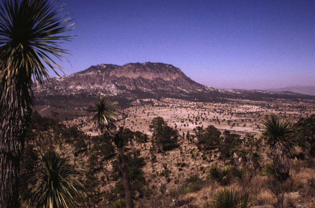 The Cerro Pinto lava dome is seen here from the rim of Laguna San Luis Atexcac maar, just south of Highway 140. The dome grew within a cone with a crater about 2 km wide. The crater overlaps with that of the Cerro Xalapasco cone to the north. Photo by Lee Siebert, 1998 (Smithsonian Institution).
