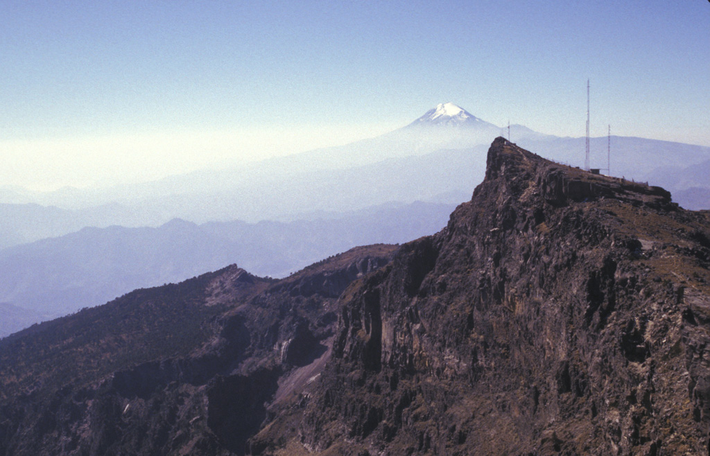 The eastern side of the summit of Cofre de Perote contains a steep escarpment. The volcano lies at the NNE end of a N-S-trending range that extends 50 km S to glaciated, historically active Pico de Orizaba (Citlaltépetl) in the distance. Like other N-S volcanic chains in México perpendicular to the Mexican Volcanic Belt, volcanism in the Cofre-Orizaba chain has migrated to the south. Photo by Lee Siebert, 1998 (Smithsonian Institution).